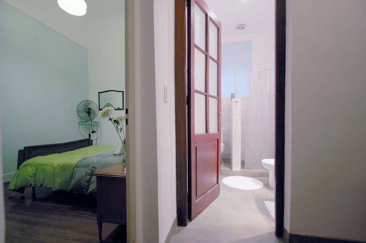 A separate bathroom with original door from the conventillo days.