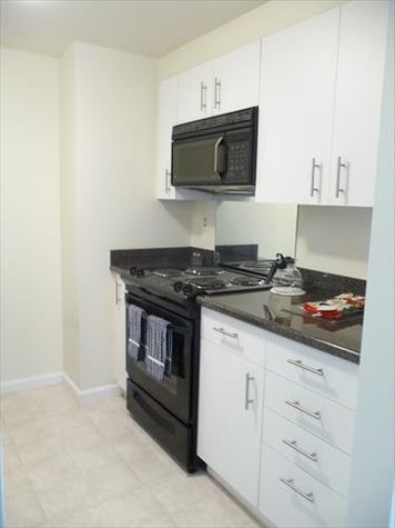 Fully equipped kitchen with appliances, pots, pans and dishes.
