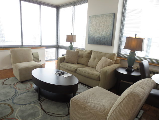 Comfortable living room with pullout sofa bed and over-sized windows providing natural light and views