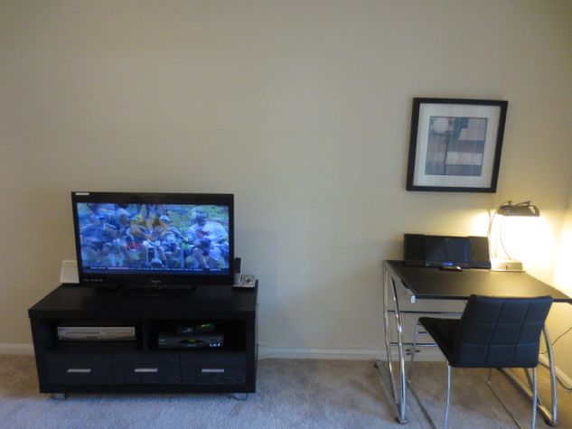 Living room with entertainment center and convenient work desk with chair, lamp and WiFi
