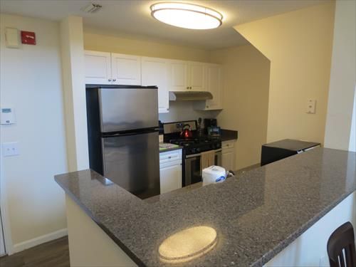 Fully equipped kitchen with stainless steel appliances, pots, pans and dishes