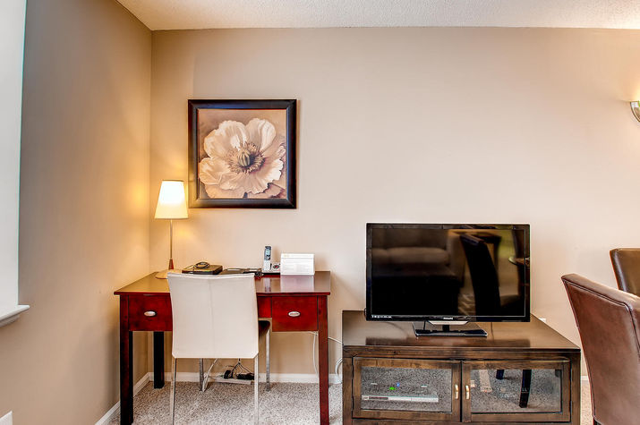 Living room with convenient work desk and entertainment center including flat panel LCD TV, DVD/VCR player and CD stereo system