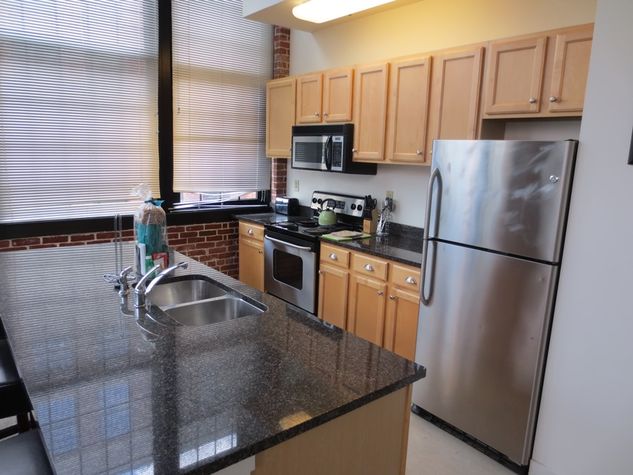Fully equipped kitchen with stainless steel appliances, granite counter tops, pots, pans and dishes