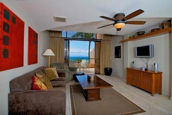 Spacious fully furnished living room with TV and a stunning ocean view