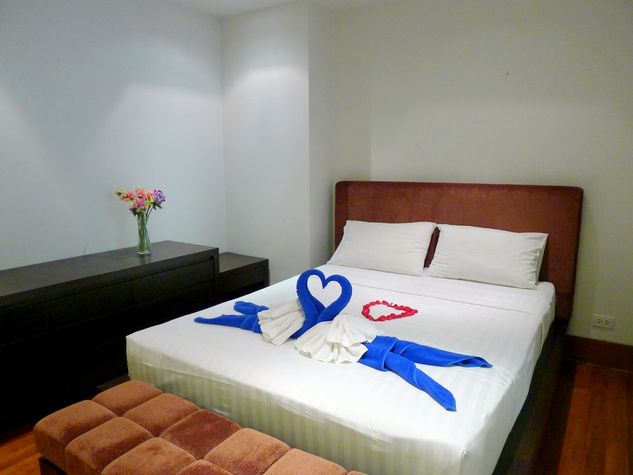 Guest bedroom with double bed, low closet and a couch