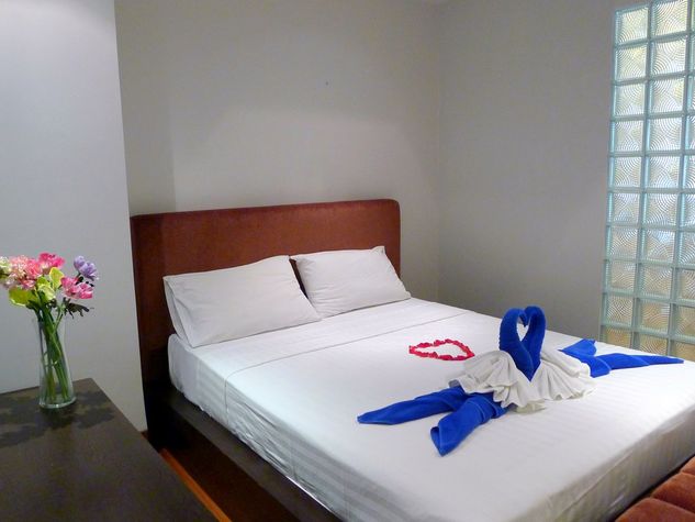 Guest bedroom with double bed, low closet and a couch
