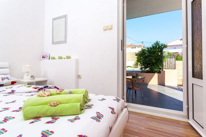 White bedroom with a terrace and access to swimming pool