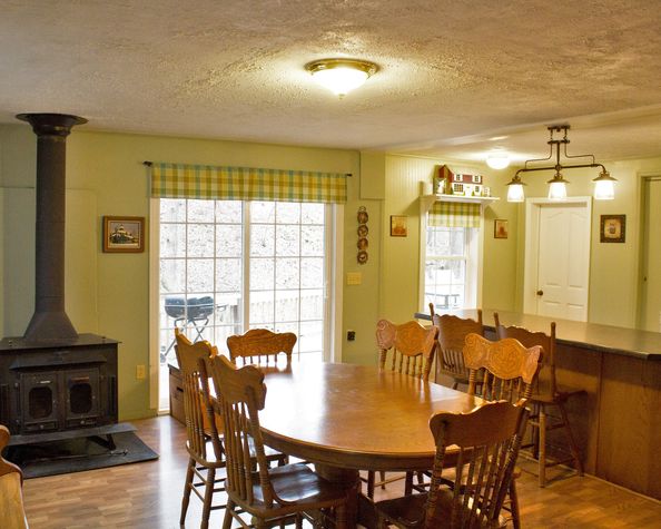 Buck stove for keeping warm in cabin/cottage style. Patio doors open to deck.