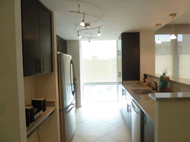 Fully equipped kitchen with stainless steel appliances, pots, pans and dishes