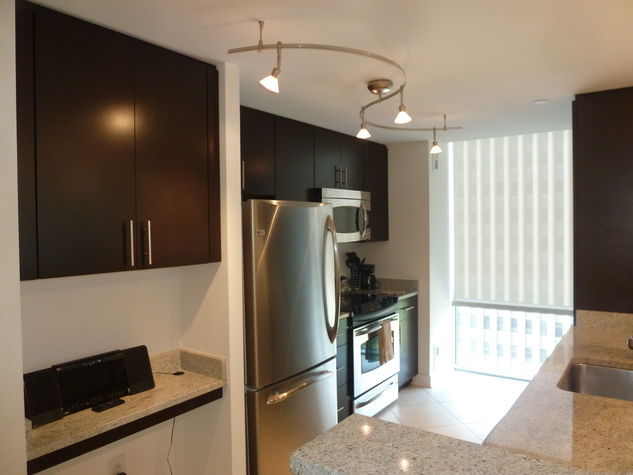Fully equipped kitchen with stainless steel appliances, pots, pans and dishes