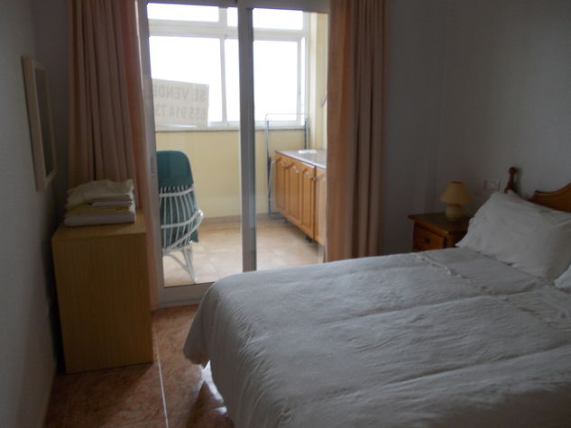 bedroom with patio window leading onto balcony