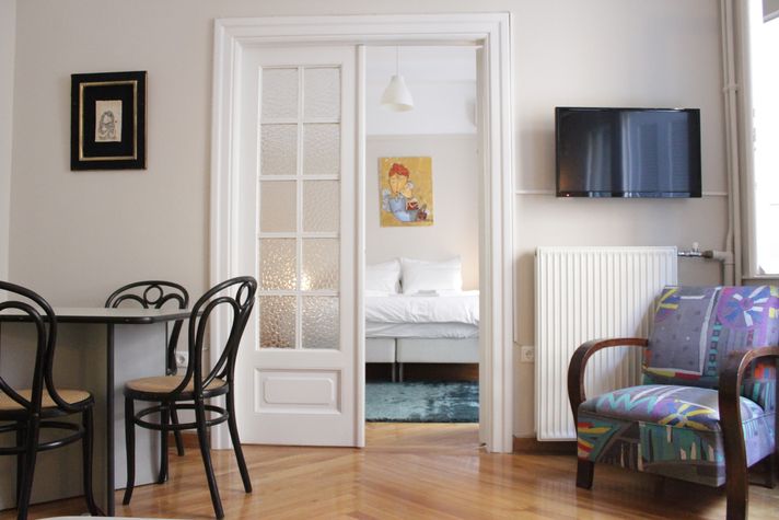 Living room, dining table and bedroom in the background