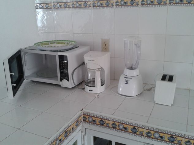 Horno de microondas, cafetera, licuadora y tostadora.