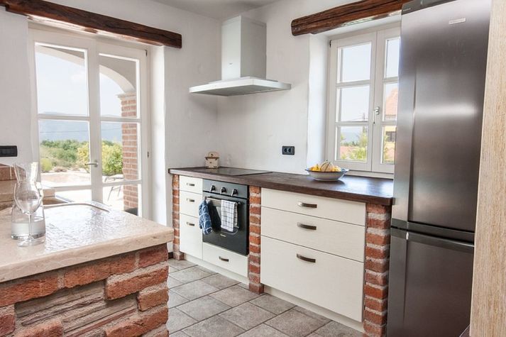 Stone kitchen with fool rustical wood, freezer and wine cooller.