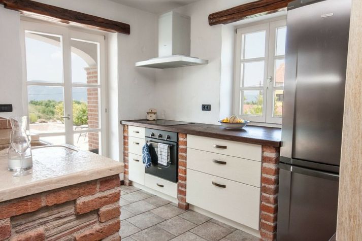 Stone kitchen with fool rustical wood, freezer and wine cooller.