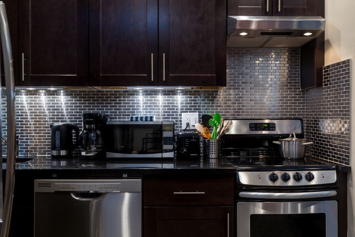 Detail of stainless steel backsplash and black granite countertop