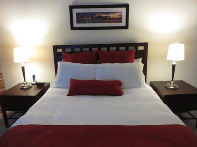 The bedroom features a deluxe queen size bed with our indulgent custom linens, fluffy duvet, and plush pillows