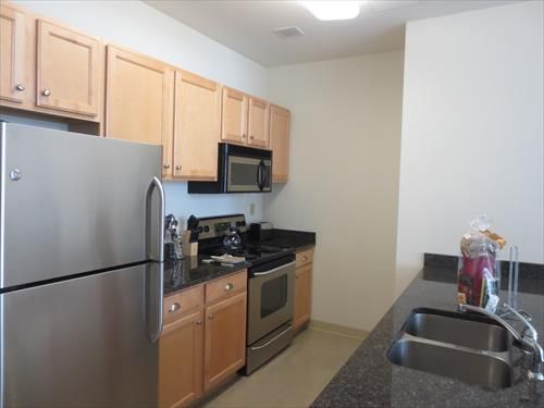 Fully equipped kitchen with stainless steel appliances, granite counter tops, pots, pans and dishes