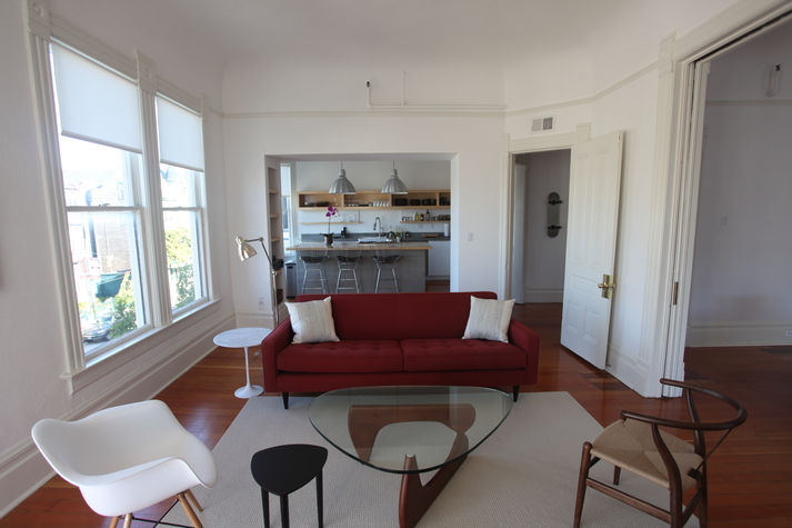 Living room with modern furniture; opens up to kitchen and dining room