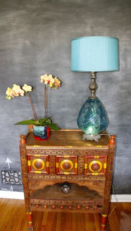 Old Central Asian cabinet with mid century flea market lamp and chalkboard wall