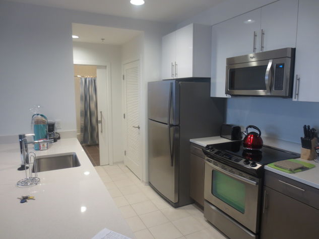 Fully equipped kitchen with stainless steel appliances, pots, pans and dishes