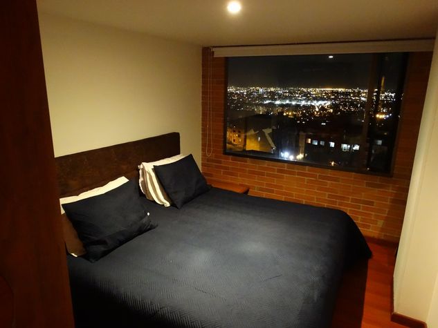 Bedroom with bed at night with view of Bogota
