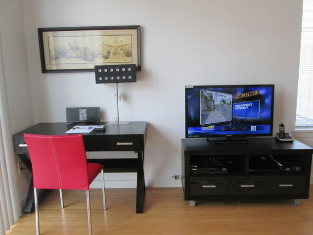 Living room with entertainment center and convenient work desk with chair, lamp and WiFi