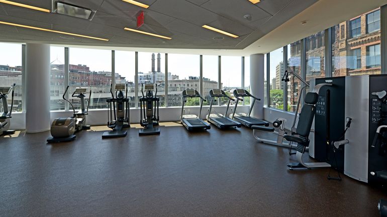 Large fitness center with cardio, weight machines and over-sized windows providing lovely natural light and amazing cityviews