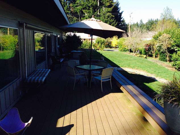 Big deck that has furniture and a grill.